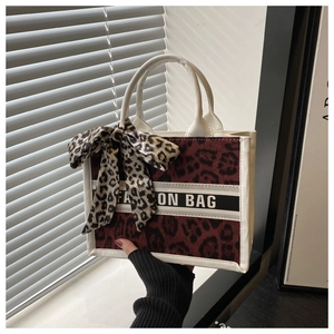 Detail of red leopard print tote bag with white leather trim and Fashion Bag ribbon