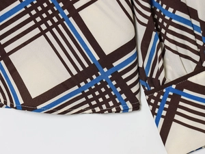 Vue macro détaillée de la texture du tissu à carreaux et des coutures aux poignets