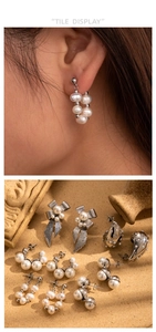 Detail shot of pearl and bow earrings set on textured stone and vintage vessel