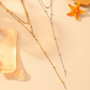 Collana a doppio strato in oro 18k e argento con sfere in acciaio e nappe a Y alla moda