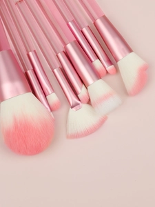 Macro shot of 9-piece makeup brush set with transparent pink handles and soft gradient bristles