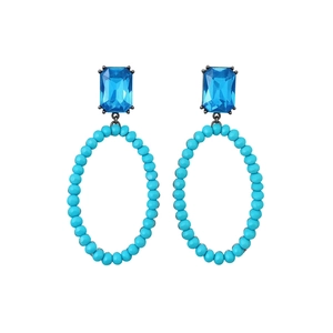 Vintage oval hollow earrings with blue crystal top and beaded charms on white background
