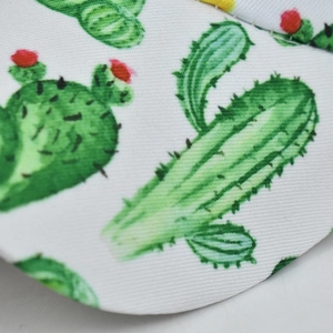 Close-up of durable twill fabric featuring a green cactus and red flower print pattern