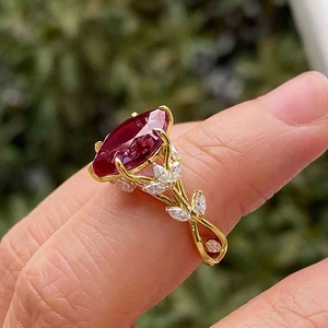 Close-up of luxury gold leaf ring with oval ruby and sparkling zircon on woman hand