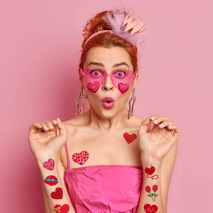 Macro detail of red heart and rose temporary tattoos on model for Valentine's Day