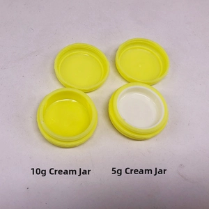 Close-up of 5g and 10g yellow plastic cream jars with screw caps for cosmetics packaging