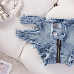 Detail der blauen Denim-Hotpants mit ausgefransten Kanten und seitlichem Reißverschluss
