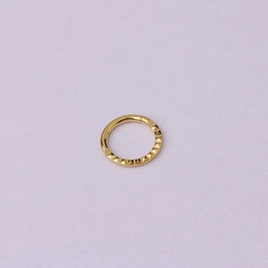 Macro shot of gold stainless steel ring featuring geometric triangle pyramid texture