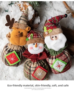 Detail of Christmas drawstring gift bags featuring Santa, snowman and reindeer plush heads