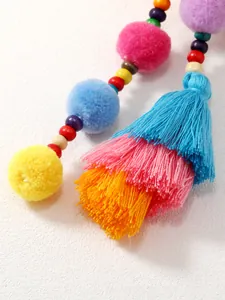 Dettaglio di pompon colorati e nappe di seta per decorazione borse e portachiavi