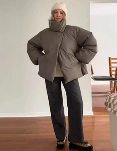 Dettaglio del piumino oversize marrone scuro abbinato a pantaloni a gamba larga