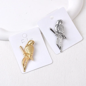 Detailed close-up of gold and silver parrot brooches with intricate feather texture
