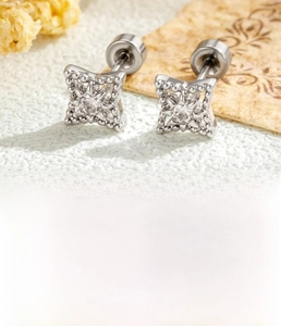 Detailed view of silver geometric stud earring with star pattern and bright zircon inlay