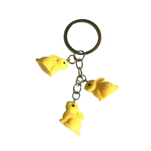Three yellow resin rabbit pendants with fur texture on a metal keychain ring