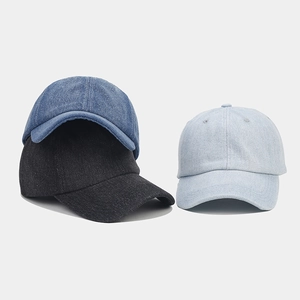 Close-up of stacked vintage washed denim baseball caps in light blue, dark blue and black