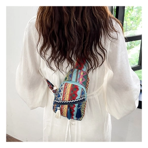 Detailed back view of ethnic woven crossbody bag featuring blue and white tassels