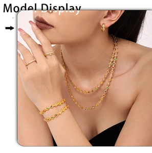Model wearing gold layered flower necklace, bracelet, and earrings with colorful enamel