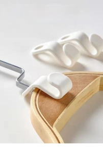 Macro detail of a white plastic clothes hanger connector hook for closet space saving