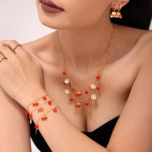 Elegant gold necklace and earrings set with red garnet beads and festive pendants