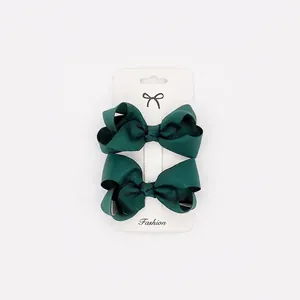 Detail of dark green grosgrain ribbon hair bows with weave texture on display card