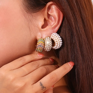 18K gold plated wide earrings set with pearls and rhinestones on a female model