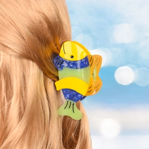 Detail view of a tropical fish claw clip made of multicolor acetate on blonde hair