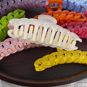 Large candy color hair claws with chain texture in various pastel shades on wood tray