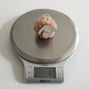 Lightweight felt sheep Christmas ornament weighing 6.5g on a digital scale for tree decor