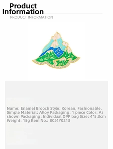 Detail view of mountain-shaped alloy brooch with blue-green enamel and white rhinestones