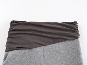 Close-up of contrast grey patchwork waistband on knit maxi skirt with fold-over detail