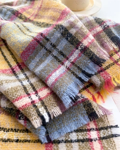 Close-up of multicolor plaid scarf showing soft brushed texture and fringed edges