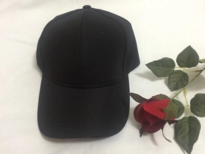 Detailed close-up of a classic six-panel black cotton baseball cap with curved brim