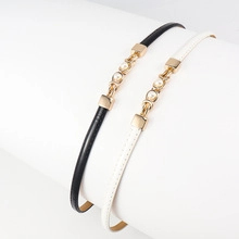 Detail of adjustable pearl belt with clover buckle in black and white leather finish