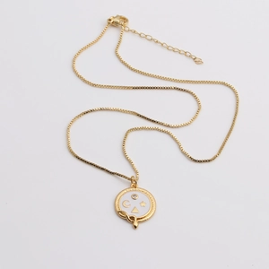 Golden necklace with snake round pendant featuring white enamel moon and star symbols