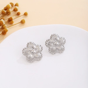 Detailed view of silver five-petal flower stud earrings with radial pleated textures