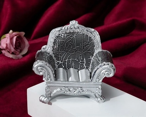 Silver vintage sofa jewelry display stand with black texture on red velvet background