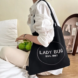 Detail eines schwarzen Kordelzug-Rucksacks mit Lady-Bug-Aufdruck in Lifestyle-Szene