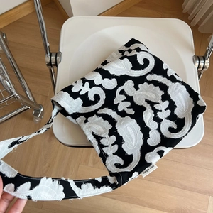 Minimalist black and white paisley embroidered linen shoulder bag with fringe edges