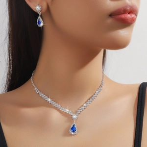 Détail du collier et des boucles d'oreilles argentés avec cristaux bleus sur modèle