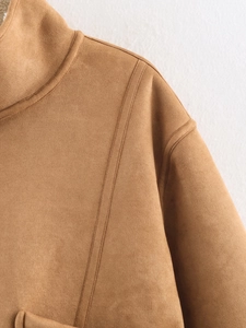 Detailed macro view of camel suede jacket fabric with premium double-stitch sewing seams