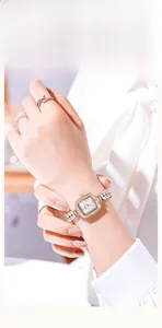 Détail d'une montre carrée or rose avec bracelet sirène en strass portée au poignet