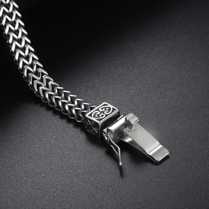 Macro view of Franco link bracelet with a decorative floral square bead and safety clasp