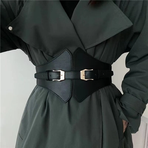 Close-up of black PU leather wide waist belt with double golden metal buckles on a model