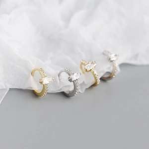 Close-up of gold and silver S925 sterling silver earrings with rectangular zircon stones