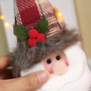 Detail einer Weihnachtsmann-Vorhangschnalle mit kariertem Hut und weißem Pelzbart