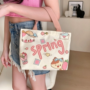 Off-white canvas tote bag featuring spring cat illustration with brown handles