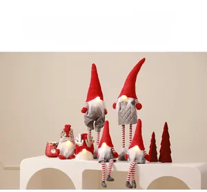Détail de gnomes de Noël lumineux en rouge et gris avec tissus en peluche et paillettes
