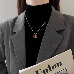 Elegant 18K gold plated horse pendant necklace with red zircon on a female model