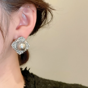 Close-up of elegant rhodium-plated earrings with grey pearl and sparkling rhinestones