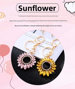 Detail of sunflower keychains with pink and yellow crystals, pearls, and gold alloy hooks